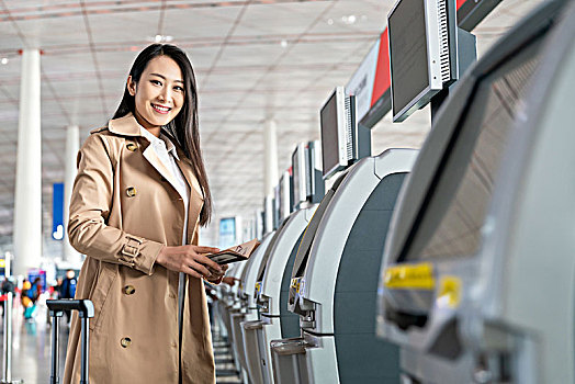 商务女子在机场使用自动售票机