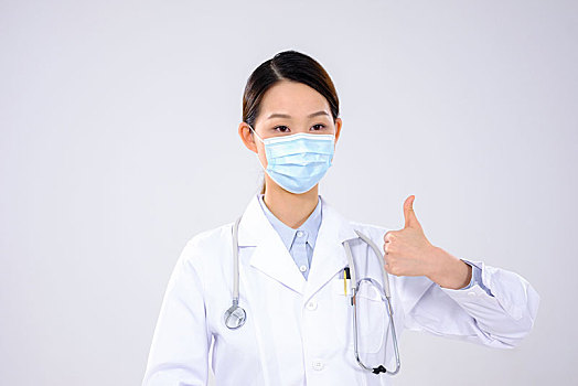 一位戴口罩的女医生伸出大拇指