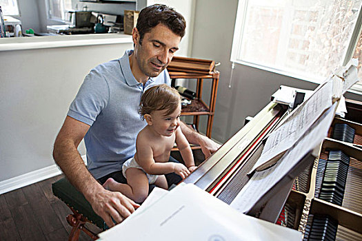男婴,坐,父亲,膝,演奏,钢琴