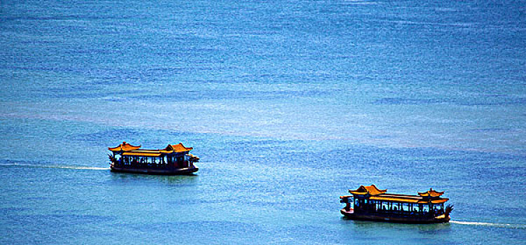 俯视两艘龙型游船行驶在昆明湖上
