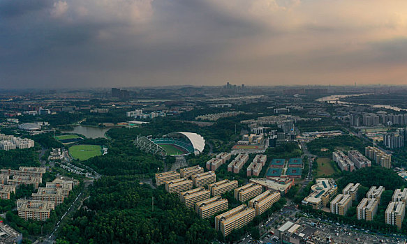 中国广东广州,航拍夏季傍晚下的广州大学城和大学城中心体育场