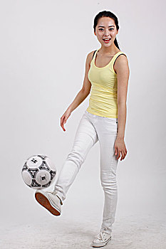 一个踢着足球的青年女士