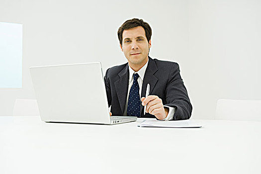 商务人士,坐,书桌,使用笔记本,电脑,看镜头,微笑