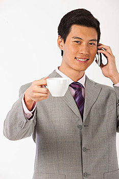 商务男士端着咖啡杯打电话