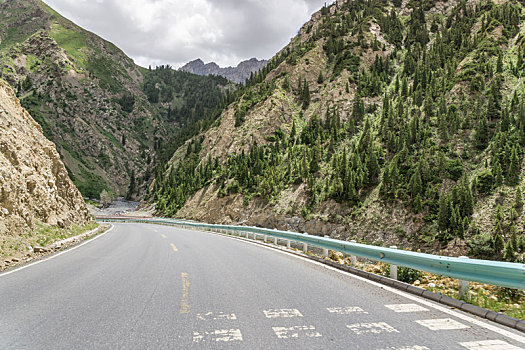 中国新疆夏季蓝天白云下高山森林g217独库公路弯道