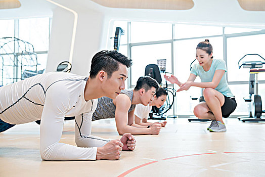 年轻人在健身房做平板支撑