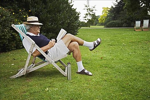 男人,坐,草坪椅,读,书本
