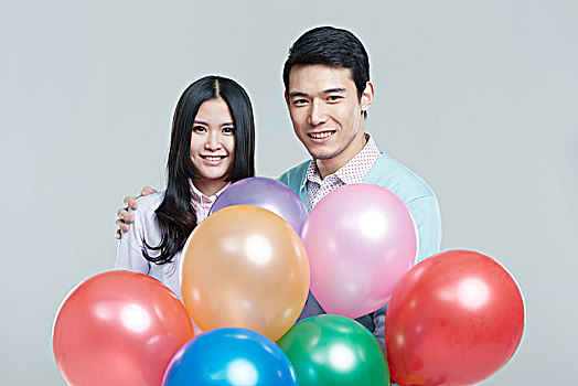 拿彩色气球的亚洲青年情侣