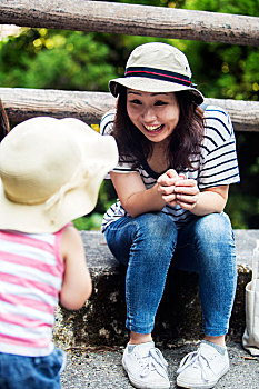 微笑,日本人,女人,交谈,小女孩,戴着,遮阳帽,条纹,上面,牛仔裤