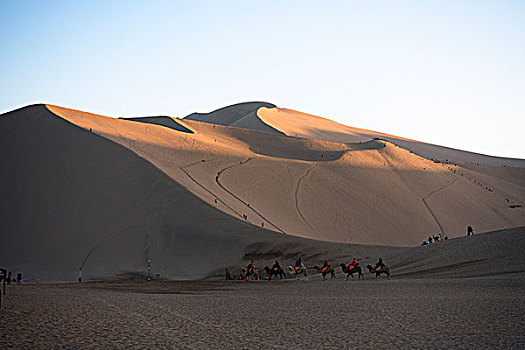 敦煌鸣沙山沙漠公园骑骆驼的游客队伍