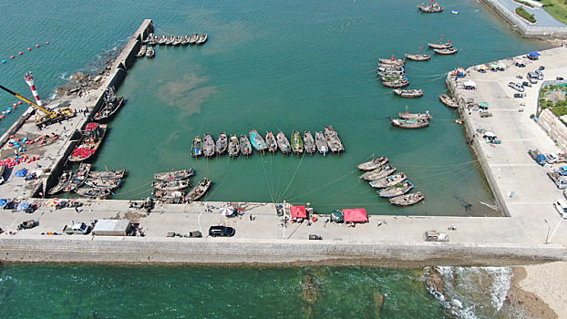 山东省日照市,航拍波光粼粼的渔码头,渔船停泊在蓝色港湾
