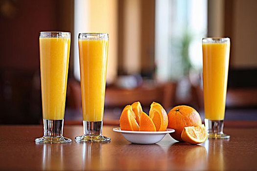三个,玻璃杯,橙汁,桌子,橘子片