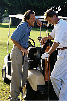 两个男人,靠着,高尔夫球车,交谈