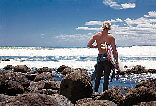 年轻人,男性,冲浪,看,海洋,海滩,石头