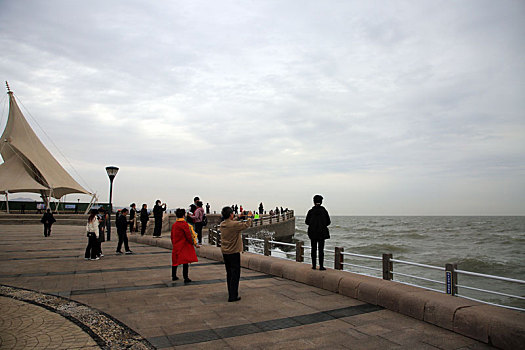 山东省日照市,大风带来滔天巨浪,游客淡定自如欣赏惊涛拍岸奇观