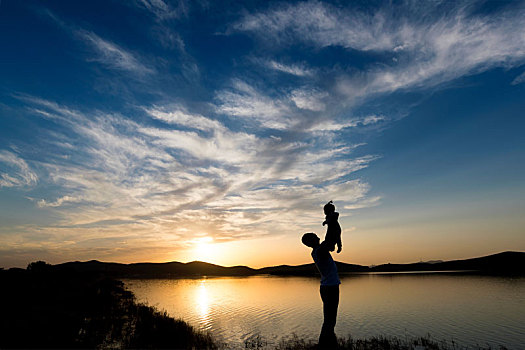 父亲高高举起孩子的剪影