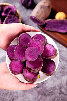 手端一盘切开的紫薯