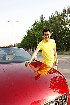一个男青年清洗汽车