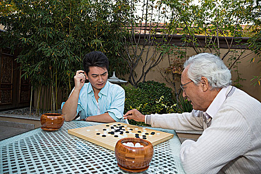 父子在庭院里下棋