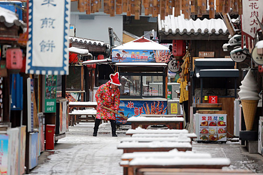 雪后的旅游小镇如诗如画,游客漫步美食街