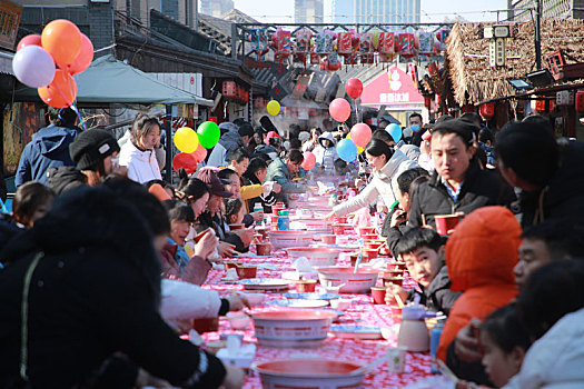 小镇摆下百米长桌宴,市民游客新年吃饺子交好运