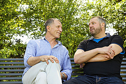 两个男人,坐,公园长椅,交谈