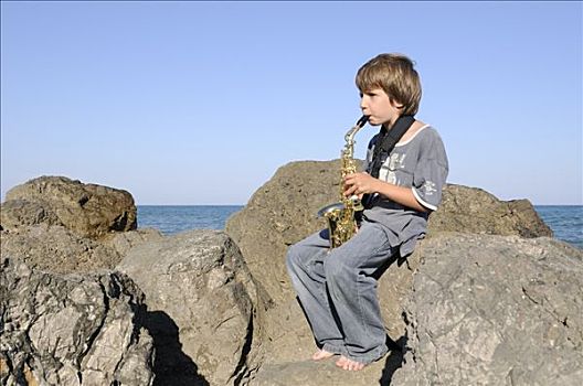 男孩,演奏,萨克斯管,岩石上,海岸线