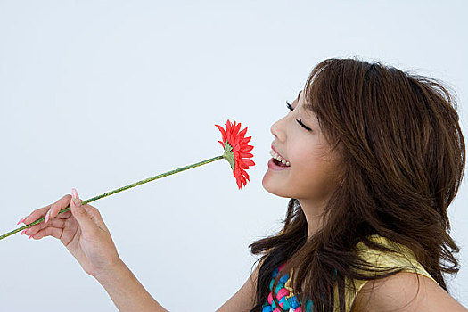 一个年轻漂亮的女人拿着花对着镜头摆姿势
