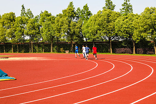 在学校运动场跑道上跑步的学生