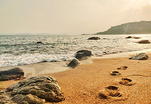 黄昏的金色沙滩脚印脚印细沙海沙沙滩纹理沙滩脚印金色沙滩海边沙子沙滩质感黄昏海水海浪
