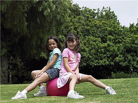 两个女孩,7-9岁,坐,粉色,留白,公园,微笑,侧面视角,头像