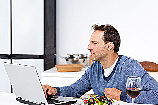 专注,男人,看,笔记本电脑,吃饭,沙拉,厨房