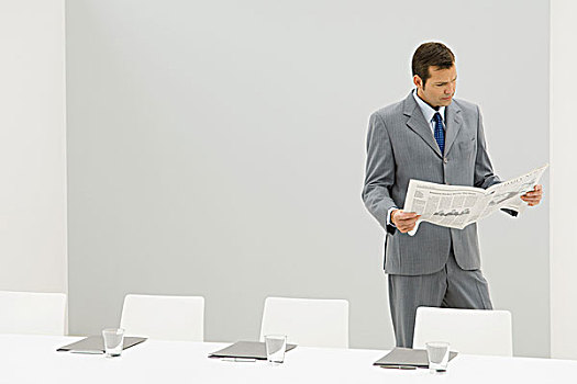 商务人士,站立,旁侧,空,会议桌,读报