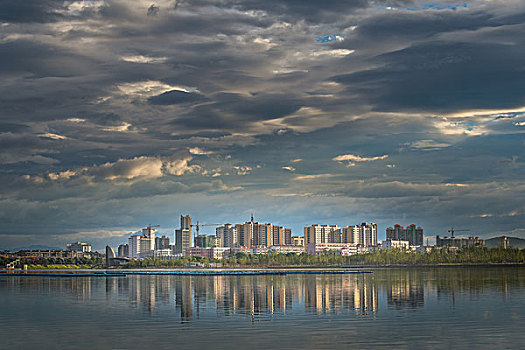 建筑群,高楼,河,灯,夜景,夕阳,倒影,云霞,乌云,城市夜景,草,剪影,风光,水面,奇景