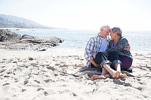 老年,夫妻,坐,海滩,搂抱,面对面,微笑