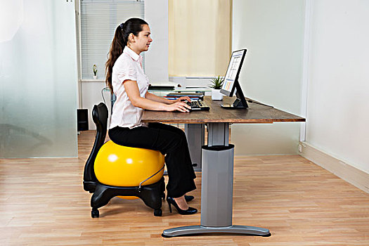 职业女性,坐,健身球,电脑,书桌