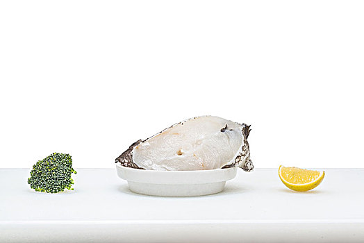 新鲜的生鳕鱼块摆放在餐桌上