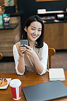 年轻女子在餐厅使用手机
