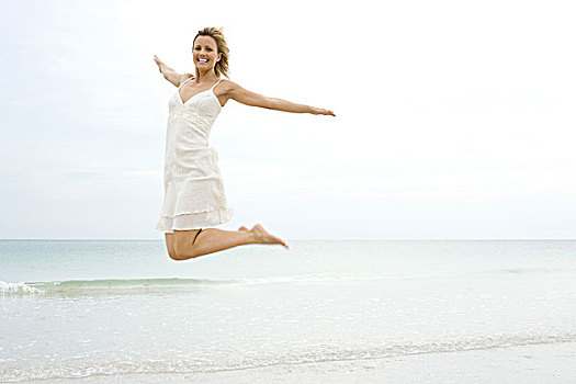 女人,跳跃,半空中,水边,伸出胳膊,腿,背影,看镜头,微笑