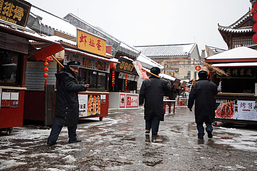 雪后的旅游小镇如诗如画,游客漫步美食街