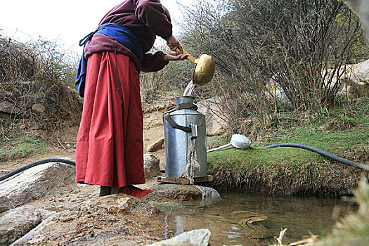 西藏拉萨米穷日寺的尼姑们在泉水边打水