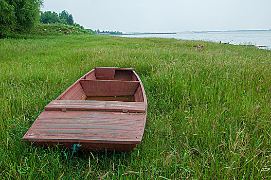 停在湖边草地的小船
