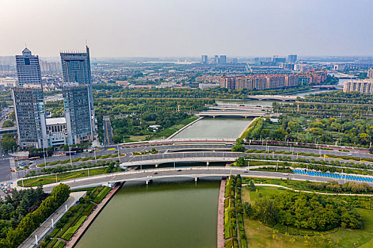 航拍河南省郑州市郑东新区cbd城市环形建筑群,如意湖水系上的道路桥梁