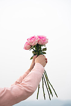 手拿一束玫瑰花