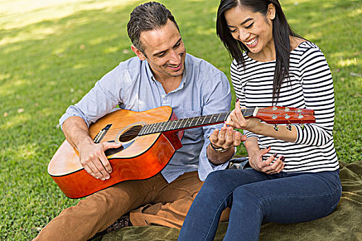 坐,夫妇,草地,演奏,木吉他,微笑