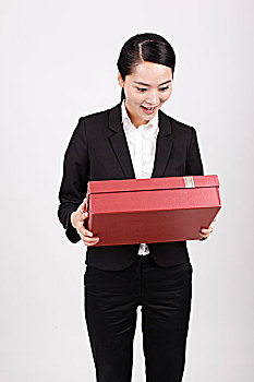 一个商务女士拿着礼物盒