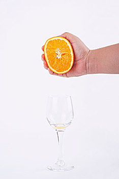 用手挤橙汁到玻璃杯里
