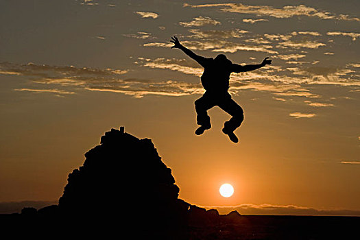 纳米比亚,纳米比诺克陆夫国家公园,剪影,男人,跳跃,石头,累石堆,日落