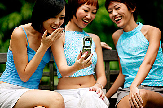 三个女人,年轻,坐,并排,拍照手机