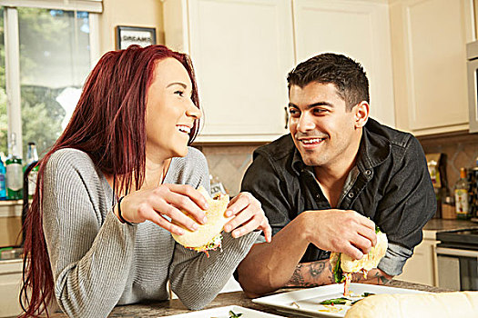 年轻,情侣,吃,三明治,厨房操作台